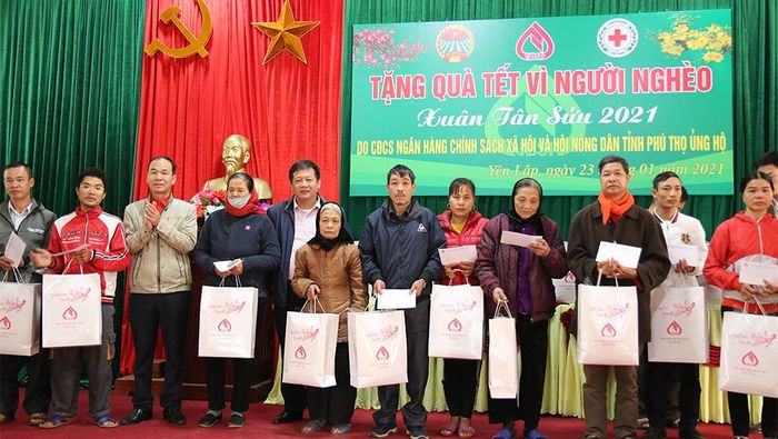 Đại diện Ngân hàng Chính sách xã hội tỉnh và Hội CTĐ huyện Yên Lập trao quà cho các hộ nghèo trên địa bàn xã Đồng Lạc. 