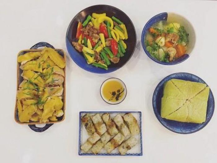 Mâm cỗ đơn giản, ấm cúng bao gồm: Thịt gà luộc; thịt bò xào ngô bao tử, đậu cove, ớt chuông; canh khoai tây cà rốt ninh sườn; nem rán và bánh chưng.