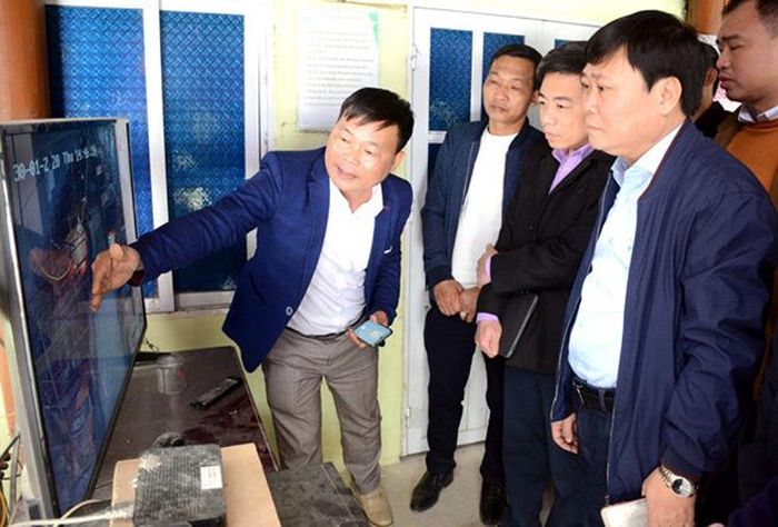 Anh Nguyễn Ngọc Sáng (bên trái) giới thiệu trang trại nuôi lợn qua hệ thống camera.