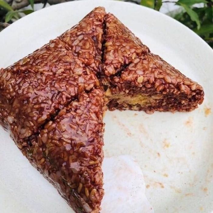 Bánh chưng gạo lứt có cách chế biến tương tự bánh chưng truyền thống. Tuy nhiên, thay vì gạo trắng, vỏ bánh được làm bằng gạo lứt. Giá của loại bánh này là từ 55.000 - 100.000 đồng/chiếc, tùy trọng lượng. Ảnh: Facebook.