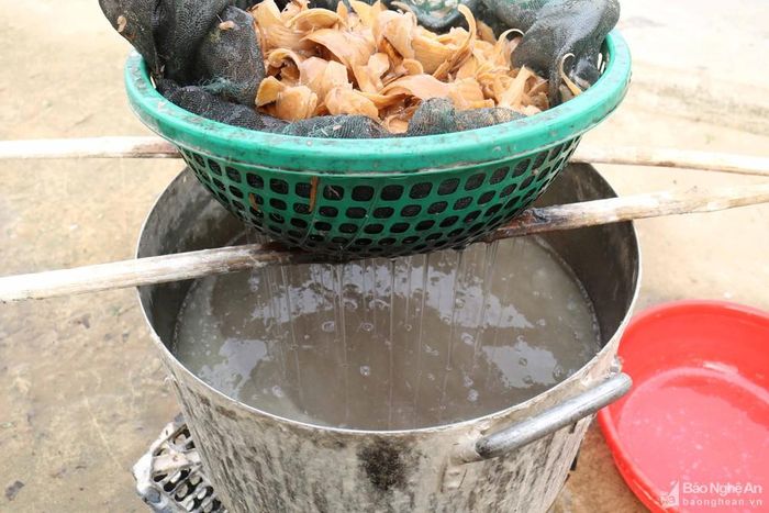 Vỏ niệt giã nhỏ được tẩy trắng, cho vào chậu khuấy đều cùng với nước lã và nhựa cây bìm bìm. Căn cứ vào độ dày mỏng của giấy người thợ sẽ pha hỗn hợp vỏ niệt lỏng hay đặc. Khâu chuẩn bị nguyên liệu là vất vả nhất trong các công đoạn của nghề làm giấy dó. Ảnh: Huy Thư