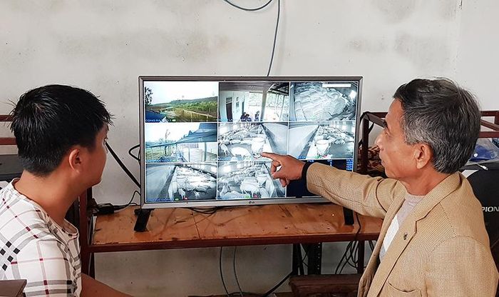  Ông Võ Doãn Thụ trao đổi với công nhân chăm sóc trang trại lợn qua màn hình camera từ nhà điều hành - Ảnh: TÚ LINH 