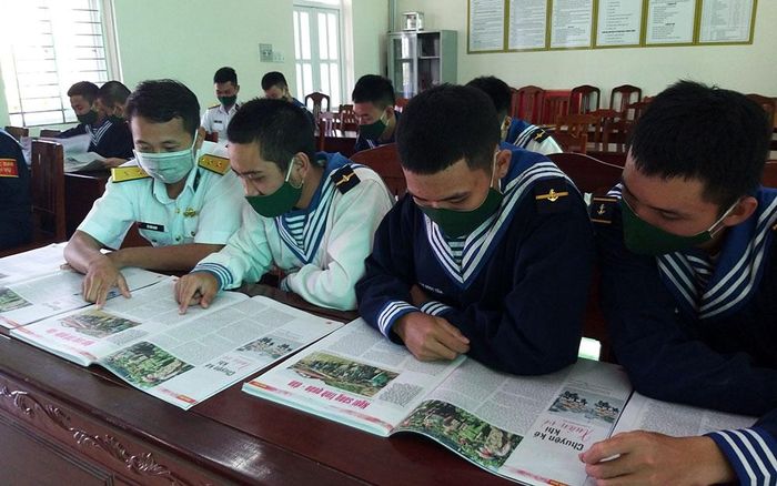  Các chiến sĩ vùng 2 Hải quân đón nhận ấn phẩm báo Xuân Nhân Dân trong giờ nghỉ giải lao. 