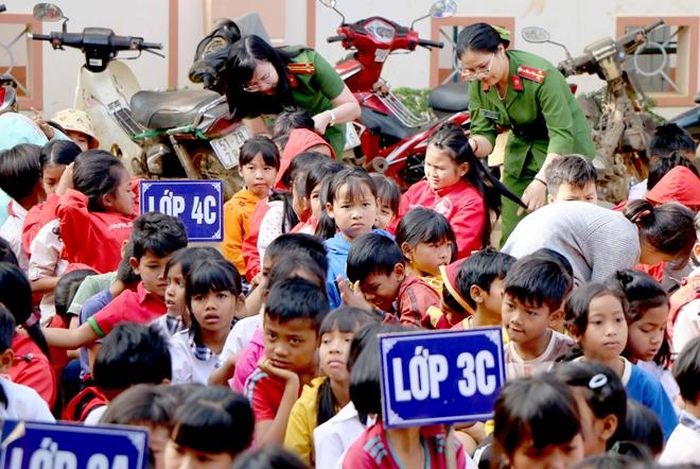 Các nữ cán bộ Công an quan tâm đến các em học sinh.