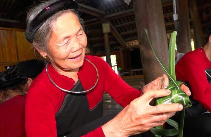 Bà Lê tỉ mẩn với công đoạn cho gạo vào bánh chim gâu. Ảnh: B.Loan