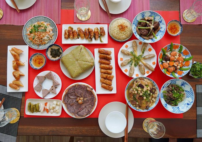 Mâm cỗ 8 người ăn với bánh chưng, bắp bò ngâm mắm, chả giò, nem rán... là gợi ý cho các gia đình đông thành viên. Có thể thấy, bữa ăn là sự kết hợp giữa ẩm thực truyền thống và hiện đại với nhiều món ngon biến tấu, trình bày đẹp mắt. Người nội trợ thường dành một tuần trước Tết để đi chợ mua nguyên liệu và chuẩn bị. Ảnh: Mai Lap Lanh.