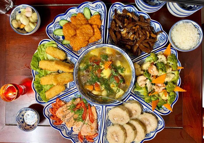  Mâm cơm mà độc giả Nguyễn Mai chia sẻ có thể là gợi ý nếu bạn không có nhiều thời gian nấu nướng. Bữa ăn có gà luộc, bánh tét, canh củ, dưa hành... chuẩn bị trong khoảng 1 giờ đồng hồ. Để mâm cúng trở nên đẹp mắt, bạn nên bày biện trong chén đĩa họa tiết đồng bộ. Ảnh: Nguyễn Mai. 