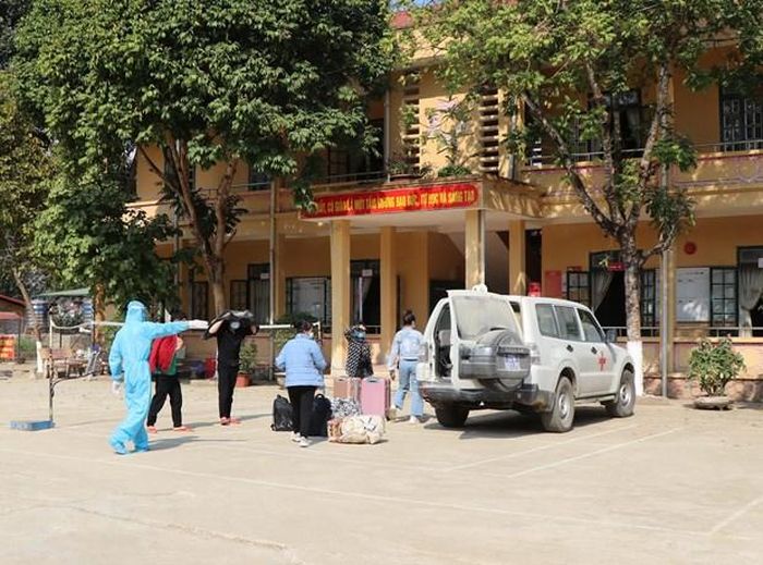 Huyện Mường Ảng đưa các trường hợp cách ly đến khu cách ly tập trung. (Ảnh: Xuân Tiến/TTXVN)