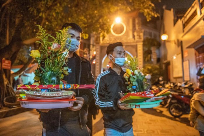  Anh Hoàng cùng bạn mua 2 mâm lễ trước cổng phủ với giá 150.000 đồng mỗi mâm để hành lễ, xin tài lộc, may mắn. 