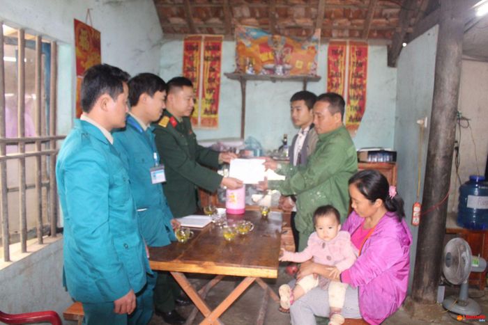 Đại diện Ban CHQS huyện Thanh Chương tặng quà, động viên gia đình thanh niên có hoàn cảnh khó khăn chuẩn bị lên đường nhập ngũ.
