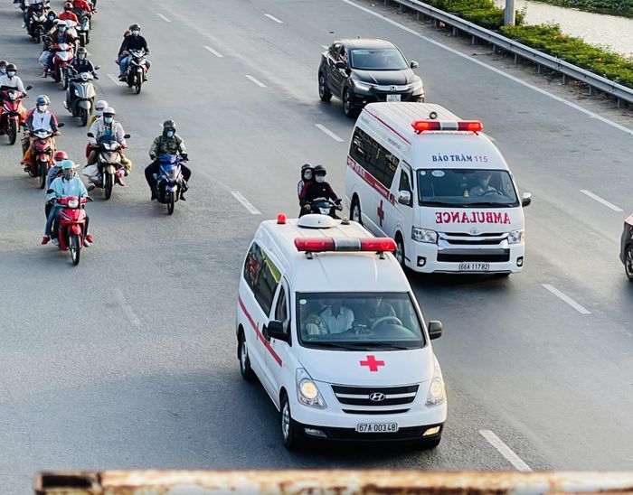 Hai xe cấp cứu di chuyển khó khăn trong dòng xe cộ.