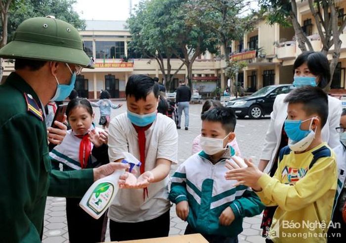 Học sinh Trường Tiểu học Cửa Nam 1 (thành phố Vinh) rửa tay bằng nước sát khuẩn trước khi vào lớp. Ảnh: MH