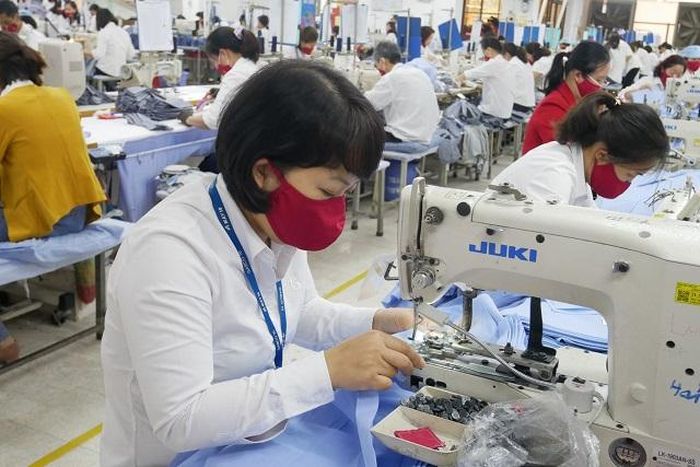 Công nhân May 10 đảm bảo phòng chống dịch và nỗ lực sản xuất ngay trong những ngày đầu năm. Ảnh: Hoàng Anh