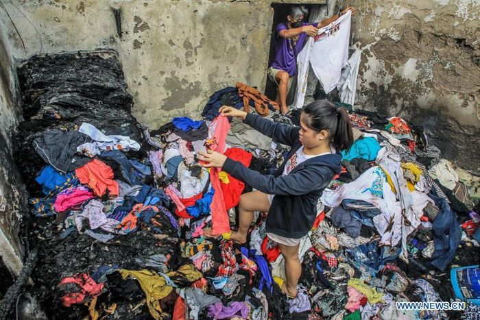  Người dân trở về nhà ở khu ổ chuột Parola, quận Tondo, Manila và thu lượm quần áo, tài sản còn sót lại sau vụ hỏa hoạn. Ảnh: Tân Hoa xã. 