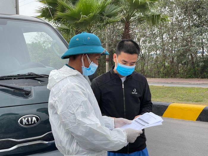Lực lượng chức năng hướng dẫn khai báo y tế đối với các tài xế ra, vào khu công nghiệp. 