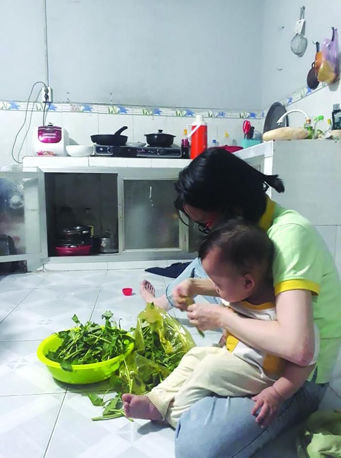 Chị và đứa con thứ hai chuẩn bị bữa ăn trong dịp Tết Tân Sửu vắng chồng, thiếu cha