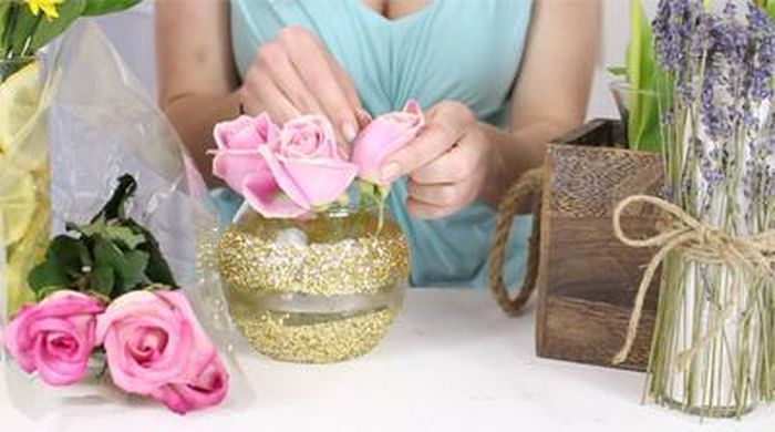 Tiếp đến, bạn dùng kéo cắt ngắn các cành hoa hồng cắm vòng ngoài sát miệng bình, nhớ đổ nước vào ½ bình. Bạn cắt cắm thêm vài cành hoa hồng cao hơn giữa bình. Bạn đừng quên cắm thêm cành baby xen giữa cành hoa hồng cho bình hoa thêm yêu nhé!