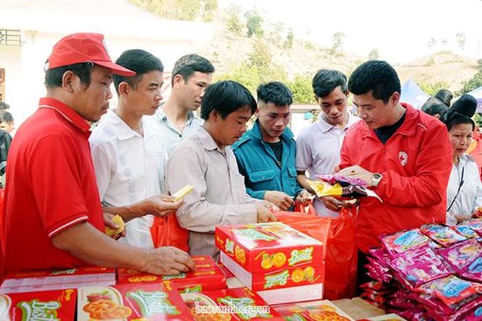 Người dân xã Nậm Ét (Quỳnh Nhai) nhận nhu yếu phẩm tại chợ nhân đạo (ảnh chụp trước ngày 26/1).
