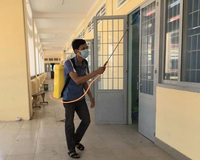 Phun thuốc khử khuẩn bên ngoài phòng học Trường THPT Nguyễn Huệ.