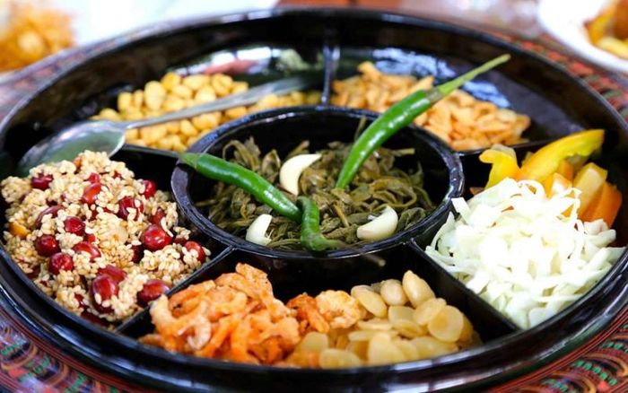 Salad lá trà: Một trong những món ăn ngon ở Myanmar nổi tiếng tiếp theo là món salad lá trà muối. Các lá trà muối có vị chua chua, đắng đắng được trộn cùng với bắp cải thái sợi và cà chua, đậu rán giòn cùng với các loại hạt còn có chút dầu tỏi, ớt, tỏi tươi thái lát. Món này có thể dùng để ăn vặt, khai vị hoặc ăn cùng với cơm như một món chính.