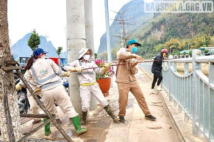 Nhiều công nhân hợp sức để kéo các bao rác lên bờ.