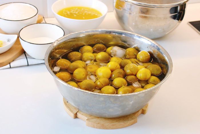  Bạn đun nước sôi, cho tắc, một ít muối vào nấu khoảng 5 phút, sau đó tắt bếp, đậy vung thêm 5 phút. Sau đó, bạn vớt tắc ra và cho vào nước đá, bóp nhẹ và để ráo. Việc cho vào nước đá lạnh giúp vỏ tắc giữ được độ tươi, giòn, sên mứt sẽ ngon hơn. 
