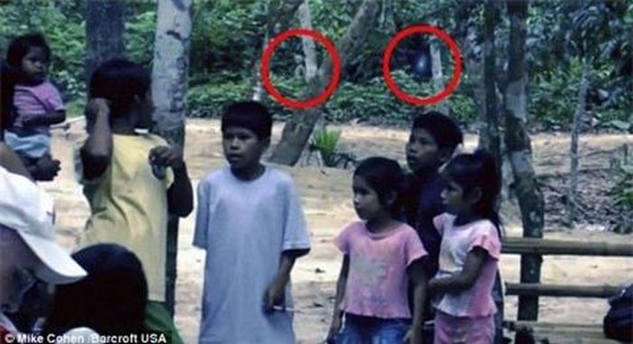 Đằng sau những đứa trẻ này có một ánh sáng nhấp nháy (vòng tròn bên phải) và một vật trông giống như người ngoài hành tinh (vòng tròn bên trái)