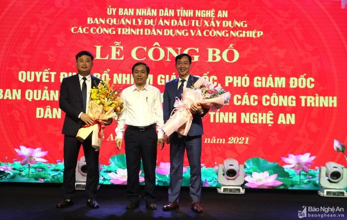 Đồng chí Lê Đình Lý - Giám đốc Sở Nội vụ tặng hoa chúc mừng 2 đồng chí. Ảnh: Nguyễn Hải