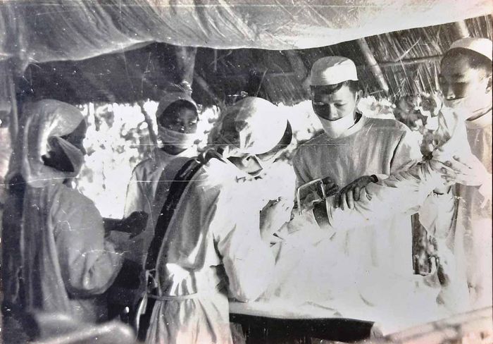 Bác sĩ Đinh Minh Chánh (người cầm cưa) và các đồng nghiệp trong 1 ca phẫu thuật ở chiến trường, năm 1968. (ảnh tư liệu do N.Q.T sưu tầm).