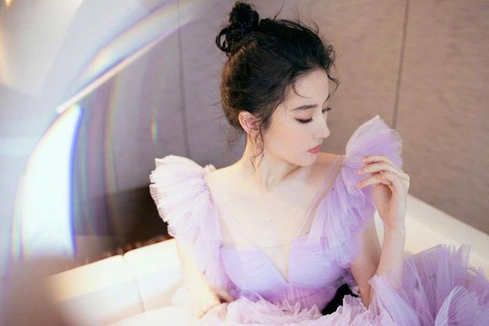 Cô diện chiếc váy màu tím nhạt, búi tóc cao và khéo léo để lộ phần xương quai xanh quyến rũ