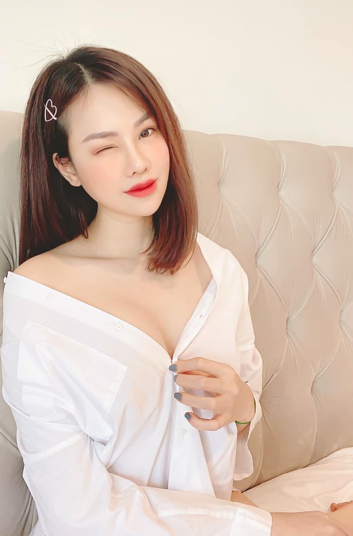 Người đẹp tự tin khoe bờ vai nõn nà cùng vòng một lấp ló trong chiếc áo sơ mi trắng bung cúc.