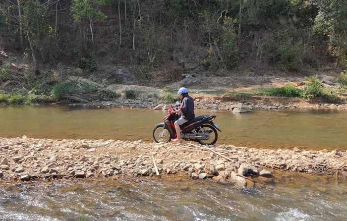 Người dân chạy xe qua con suối vào mùa khô. Ảnh: Hà Phương
