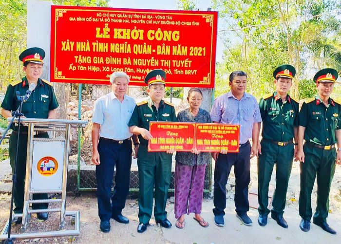 Đại diện Bộ CHQS tỉnh Bà Rịa-Vũng Tàu và chính quyền địa phương trao biển tượng trưng tặng nhà tình nghĩa cho bà Tuyết.