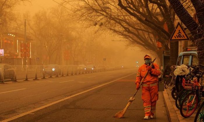 Thủ đô Bắc Kinh chìm trong lớp bụi màu nâu do bão cát sáng nay. Ảnh: Reuters