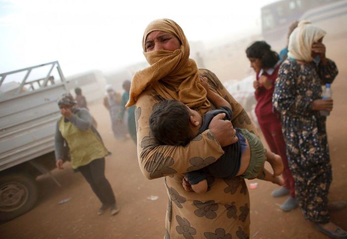  Người Kurd ở Syria đợi lên xe để đi tị nạn tại biên giới Thổ Nhĩ Kỳ - Syria ngày 24/9/2014, nhưng phải chịu đựng trận bão cát. Ảnh: Reuters. 