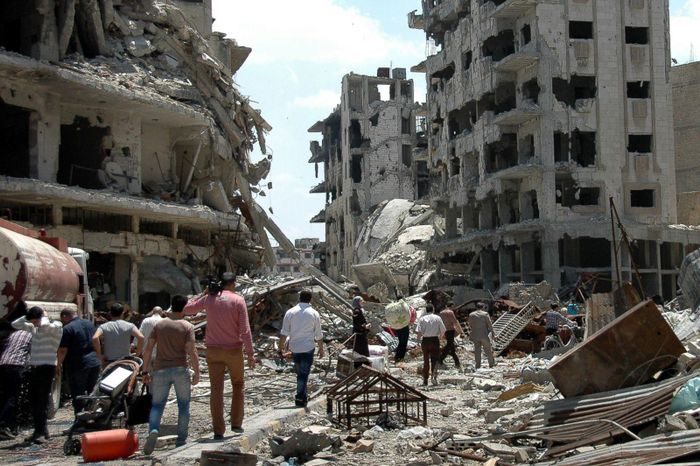 Người Syria trở về thành phố Homs ngày 10/5/2014, sau khi các chiến binh nổi dậy cuối cùng rời đi theo một thỏa thuận sơ tán. Ảnh: AFP. 