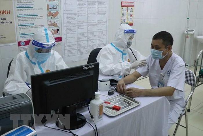 Khám sàng lọc trước khi tiêm vaccine phòng COVID-19. (Ảnh: Xuân Tiến/TTXVN)