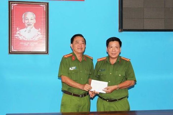 Đại tá Bùi Bé Năm, Phó giám đốc Công an tỉnh An Giang (bên trái) trao thưởng cho Công an huyện Chợ Mới.