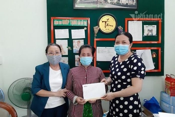 Đại diện Báo VietNamNet (phải) cùng cán bộ Phòng Công tác xã hội Bệnh viện Nhi đồng 2 (trái) trao gần 67 triệu đồng cho chị Vân.