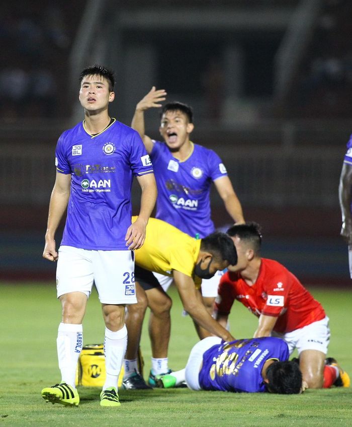  Đỗ Duy Mạnh (trái) và cầu thủ Hà Nội vội vàng gọi cứu thương vào sân. Một năm trước, cũng tại sân Thống Nhất, Duy Mạnh dính một chấn thương nặng khiến anh nghỉ thi đấu gần nửa năm. 