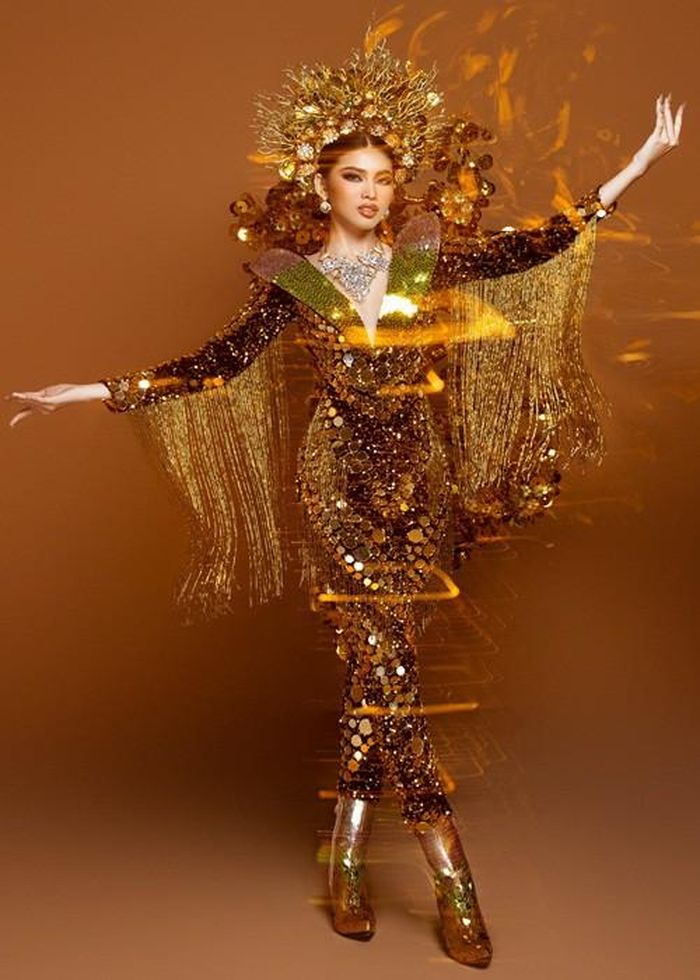 Bộ quốc phục của Ngọc Thảo bao gồm phần mấn, boots, bodysuit và phần cánh. NTK Tín Thái chia sẻ, chiếc mấn được cách điệu bởi hình tượng nhành cây và rừng hoa. Phần boots được đính bởi hàng nghìn chiếc lá óng ánh.