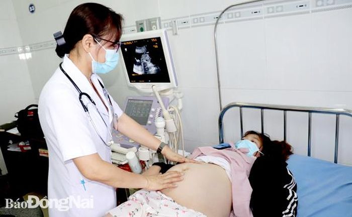Bác sĩ Hoàng Thị Du thăm khám cho một thai phụ tại Trung tâm Y tế H.Trảng Bom. Ảnh: H.Dung