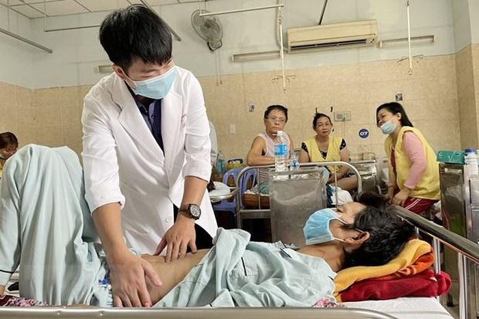 Bệnh nhân T.V.D được bác sĩ kiểm tra tình trạng sức khỏe sau phẫu thuật. (Ảnh: Lê Xuân/TTXVN)
