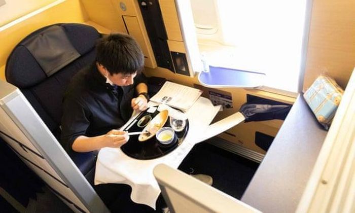 Một hành khách tận hưởng bữa ăn khoang hạng nhất