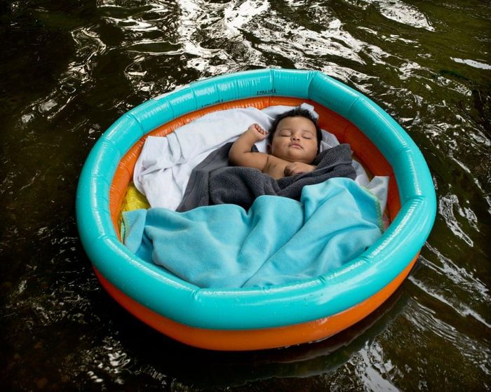  Gabriel, một em bé 9 tháng tuổi, trôi trên sông khi đang trong giấc ngủ yên bình. Cậu là một người gốc Brazil. Bức ảnh được chụp vào ngày 8/8/2020, ngày mà cô Evans "nghe thấy trên đài phát thanh rằng hơn 100.000 người Brazil tử vong do Covid-19". 