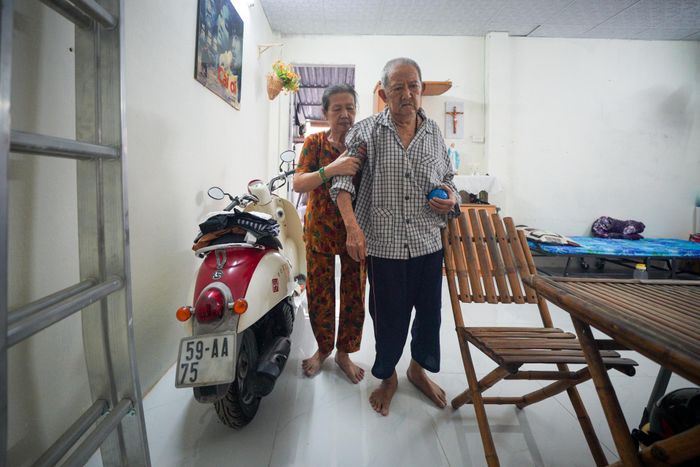  Bà Tư dìu đỡ ông khi đi lại trong nhà. Ảnh: Chí Hùng. 