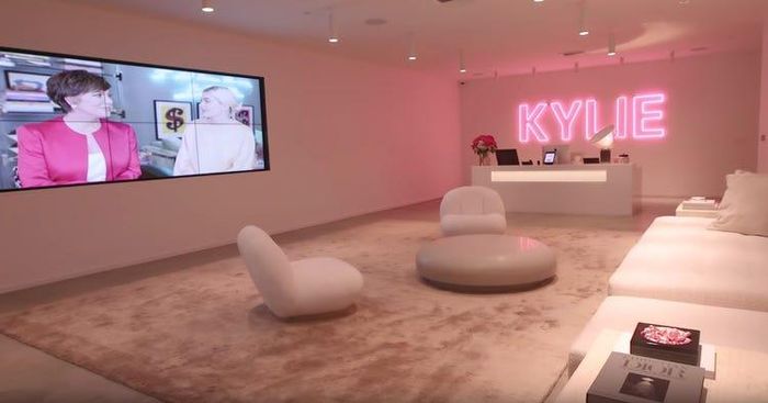  Trụ sở chính của của thương hiệu làm đẹp Kylie Cosmetics gây ấn tượng mạnh mẽ với bảng hiệu đèn neon lớn, hộp kẹo M&amp;M có gương mặt của chính tỷ phú Kylie Jenner, tác phẩm nghệ thuật làm từ son môi và phòng họp đầy những chiếc ghế xoay phủ lông vũ màu trắng. Ảnh: Kylie Jenner/YouTube. 