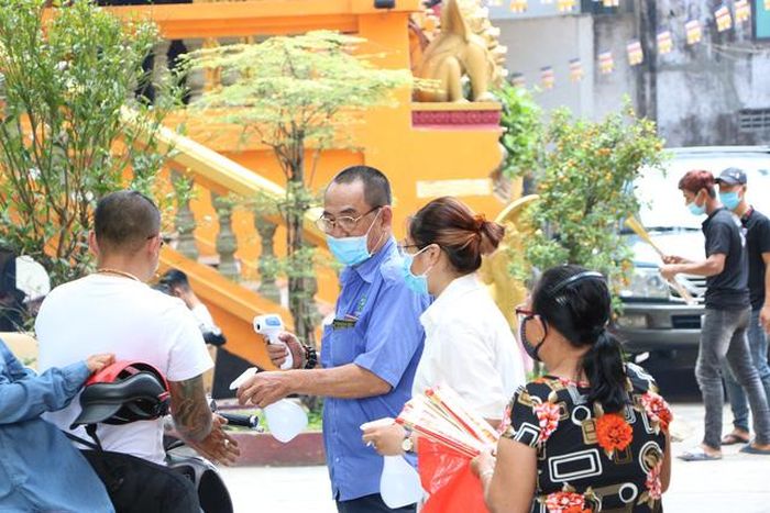 Kiểm tra thân nhiệt và rửa tay sát khuẩn trước khi vào chùa.