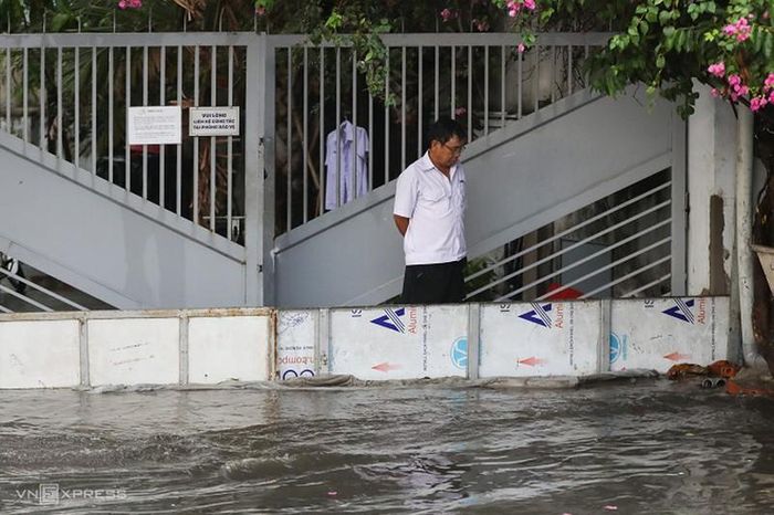 Người dân dùng bao cát, các vật dụng để chắn nước tràn vào nhà.