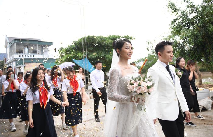 Nhiều người dân ở hai bên đường chăm chú theo dõi lễ cưới của cặp đôi Phan Mạnh Quỳnh - Khánh Vy. Theo thông báo từ người nhà, ngoài hôn lễ ở Nghệ An, cặp đôi sẽ tổ chức tại TP Nha Trang (Khánh Hòa) - quê Khánh Vy và TP.HCM trong thời gian tới. 